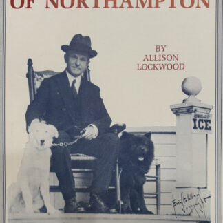 Calvin Coolidge sits in a chair next to two dogs on the cover of the book, "Presindent in a Two-Family House"
